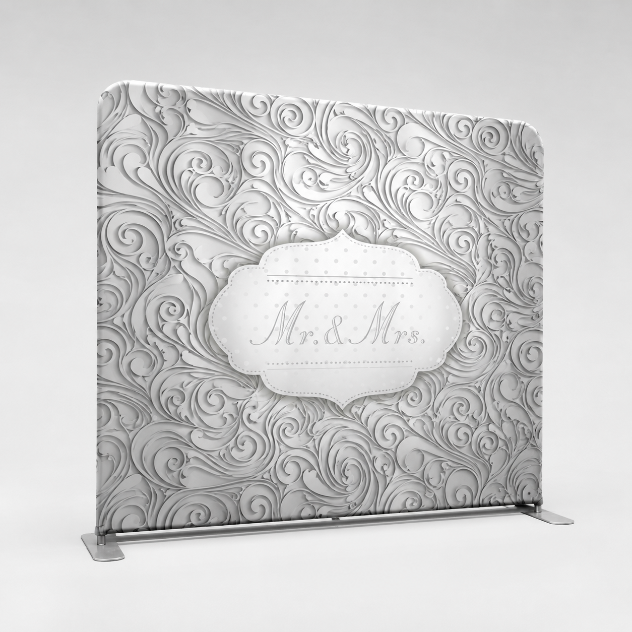 Decorative wedding backdrop with swirling damask pattern and a white oval plaque reading 'Mr. & Mrs.' at center, on a stand